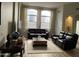 Spacious living room with a comfortable leather sofa and well-lit by large windows at 1444 W Spruce Dr, Chandler, AZ 85286