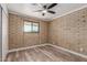 Bedroom featuring brick accent wall, wood-look flooring and a closet at 1646 W Fairmont Dr, Tempe, AZ 85282