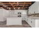 Bright kitchen features white cabinetry, an island, stainless appliances, and exposed ceiling beams at 1646 W Fairmont Dr, Tempe, AZ 85282