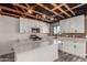 Bright kitchen features white cabinetry, an island, stainless appliances, and exposed ceiling beams at 1646 W Fairmont Dr, Tempe, AZ 85282