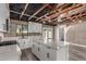 Bright kitchen features white cabinetry, an island, stainless appliances, and exposed ceiling beams at 1646 W Fairmont Dr, Tempe, AZ 85282