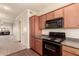 Functional kitchen featuring wood cabinets and black appliances, open to the living area at 1941 S Pierpont Dr # 2141, Mesa, AZ 85206