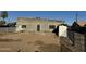 Exterior home view featuring a cinder block home with a brown dirt yard and a grey door at 206 S 5Th St, Buckeye, AZ 85326