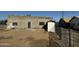 Exterior home view featuring a cinder block home with a brown dirt yard and a grey door at 206 S 5Th St, Buckeye, AZ 85326