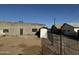 Exterior home view featuring a cinder block home with a brown dirt yard and a grey door at 206 S 5Th St, Buckeye, AZ 85326