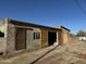 Exterior view of the cinderblock garage, including a wooden sliding door at 206 S 5Th St, Buckeye, AZ 85326