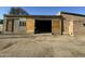 Spacious brick garage featuring large wooden sliding doors, window and dirt driveway at 206 S 5Th St, Buckeye, AZ 85326