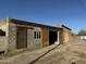 Spacious brick garage featuring large wooden sliding doors, window and dirt driveway at 206 S 5Th St, Buckeye, AZ 85326