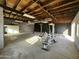 Large unfinished garage interior with wood ceiling, concrete floor, white walls and exercise equipment at 206 S 5Th St, Buckeye, AZ 85326