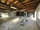 Large unfinished garage interior with wood ceiling, concrete floor, white walls and exercise equipment at 206 S 5Th St, Buckeye, AZ 85326