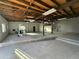 Large unfinished garage interior with wood ceiling, concrete floor, white walls and exercise equipment at 206 S 5Th St, Buckeye, AZ 85326