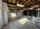 Large unfinished garage interior with wood ceiling, concrete floor, white walls and exercise equipment at 206 S 5Th St, Buckeye, AZ 85326