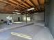 Large unfinished garage interior with wood ceiling, concrete floor, white walls and exercise equipment at 206 S 5Th St, Buckeye, AZ 85326