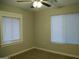 Bright bedroom featuring neutral walls, ceiling fan, and windows offering natural light at 2215 W Highland Ave, Phoenix, AZ 85015