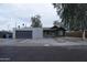Charming single-story home featuring modern stucco siding, a gray garage door, and a manicured rock garden at 2215 W Highland Ave, Phoenix, AZ 85015