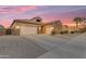 Spacious home boasting three-car garage, stone accents, and well-maintained landscaping at dusk at 22186 E Via Del Verde --, Queen Creek, AZ 85142