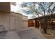 Private back patio with brick pavers, desert landscaping, and access through a wooden fence gate at 2221 W Farmdale Ave # 7, Mesa, AZ 85202