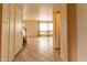 Hallway featuring tile floors leading to a bright and airy living room at 2221 W Farmdale Ave # 7, Mesa, AZ 85202