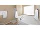 Bright bathroom featuring a large window above a soaking tub and a glass-enclosed shower at 24113 N 26Th Pl, Phoenix, AZ 85024
