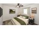 This bedroom features a ceiling fan, a bed with decorative pillows, and carpeted floors at 24113 N 26Th Pl, Phoenix, AZ 85024