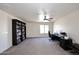 Large bonus room with neutral carpeting, ceiling fan, and built-in bookcase at 24113 N 26Th Pl, Phoenix, AZ 85024
