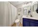 Cozy bathroom with navy vanity, neutral decor, and a classic shower curtain at 2414 W White Feather Ln, Phoenix, AZ 85085