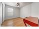 Minimalist bedroom featuring wood floors, a ceiling fan, and a small red table at 2414 W White Feather Ln, Phoenix, AZ 85085