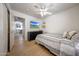Light bedroom featuring wood floors, ceiling fan, and a TV mounted on the wall at 2414 W White Feather Ln, Phoenix, AZ 85085