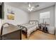 Cozy bedroom with wood floors, ceiling fan, and a black metal frame bed at 2414 W White Feather Ln, Phoenix, AZ 85085
