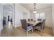 Dining room features hardwood floors, neutral walls, a modern chandelier, and a dining table with upholstered chairs at 2414 W White Feather Ln, Phoenix, AZ 85085