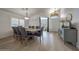 Dining room features hardwood floors, neutral walls, a modern chandelier, and a dining table with upholstered chairs at 2414 W White Feather Ln, Phoenix, AZ 85085