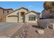 Single-story home featuring a two-car garage, desert landscaping, and a brick walkway to the front door at 2414 W White Feather Ln, Phoenix, AZ 85085