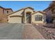 Single-story home featuring a two-car garage, desert landscaping, and a brick walkway to the front door at 2414 W White Feather Ln, Phoenix, AZ 85085