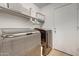 Modern laundry room featuring updated washer and dryer units and built-in shelving at 2414 W White Feather Ln, Phoenix, AZ 85085