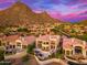 Aerial view of a desert home, nestled against a mountain backdrop, with lush landscaping and a tile roof at 24350 N Whispering Ridge Way # 22, Scottsdale, AZ 85255