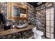Chic powder room featuring unique wallpaper, a stone vessel sink, and a rustic wood countertop at 24350 N Whispering Ridge Way # 22, Scottsdale, AZ 85255