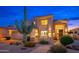 Beautiful home with manicured landscaping, a spacious driveway, and attractive facade at twilight at 24350 N Whispering Ridge Way # 22, Scottsdale, AZ 85255
