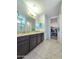 Bathroom featuring double sinks with granite countertops and a walk-in closet at 24552 W Hilton Ave, Buckeye, AZ 85326