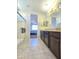 Bathroom showcasing double sinks, a shower with glass doors, and tile flooring at 24552 W Hilton Ave, Buckeye, AZ 85326