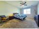 Cozy bedroom featuring carpet, a ceiling fan, and a large window that brightens the room at 24552 W Hilton Ave, Buckeye, AZ 85326