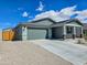 Charming home with a two-car garage and wide driveway set against a sunny blue sky at 24552 W Hilton Ave, Buckeye, AZ 85326