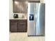 Modern kitchen featuring stainless steel refrigerator and stylish dark wood cabinets at 24552 W Hilton Ave, Buckeye, AZ 85326