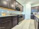 Well-equipped kitchen boasts dark wood cabinets, stainless steel appliances, and granite countertops at 24552 W Hilton Ave, Buckeye, AZ 85326