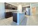 Open kitchen with dark wood cabinets, granite countertops, and stainless steel appliances at 24552 W Hilton Ave, Buckeye, AZ 85326