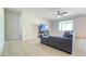 Comfortable living room featuring tile flooring, a gray sofa, and a ceiling fan at 24552 W Hilton Ave, Buckeye, AZ 85326