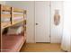 The image showcases a bedroom with wooden bunk beds, and bright white walls, a bohemian wall hanging at 3147 W Phelps Rd, Phoenix, AZ 85053