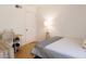 Bright bedroom featuring light wood floors, white walls, a desk, a twin bed, and a decorative lamp at 3147 W Phelps Rd, Phoenix, AZ 85053