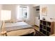Cozy bedroom with a double bed, wood floors, a large window with natural light, and a storage unit at 3147 W Phelps Rd, Phoenix, AZ 85053
