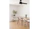 Bright dining room featuring a ceiling fan, wood floors, a dining table with chairs, and modern shelving at 3147 W Phelps Rd, Phoenix, AZ 85053