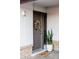 Close-up of front door featuring a wreath, fresh landscaping, stylish white walls, and neutral colors at 3147 W Phelps Rd, Phoenix, AZ 85053